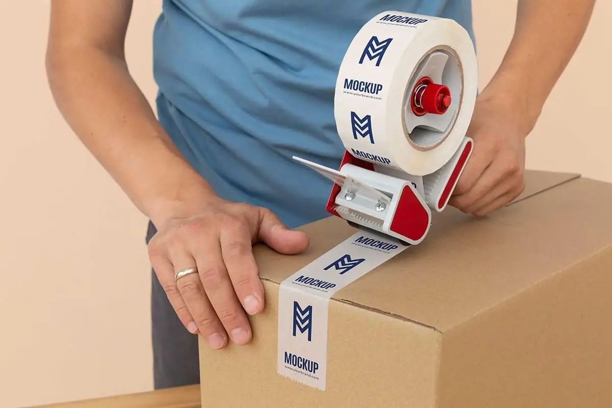 Aplikácia lepiacej pásky s potlačou loga na kartónový balík pomocou odvíjača – personalizované firemné balenie