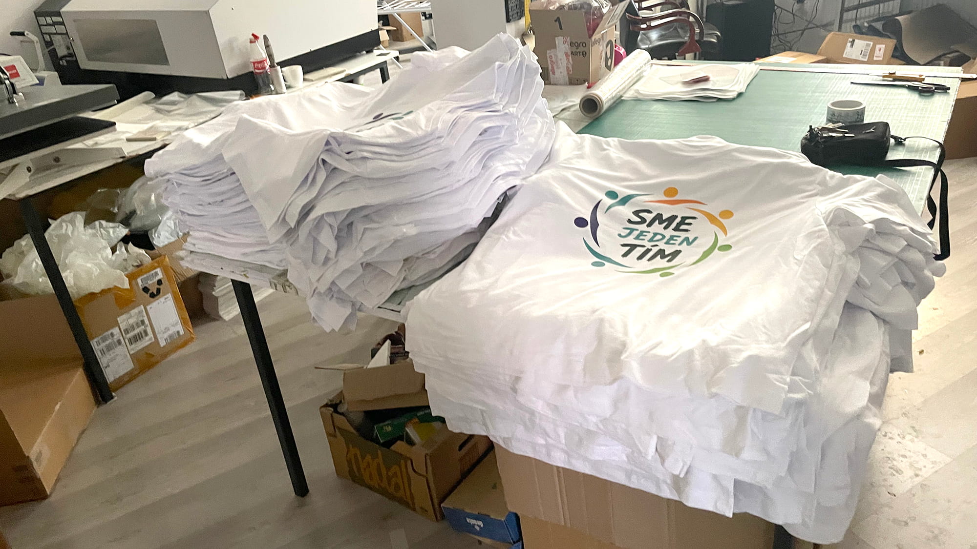 DTF potlač bielych firemných tričiek s logom na veľkú firemnú akciu.